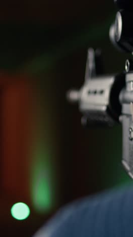 vertical video man holds rifle, enjoying shooting experience in firing range, close up