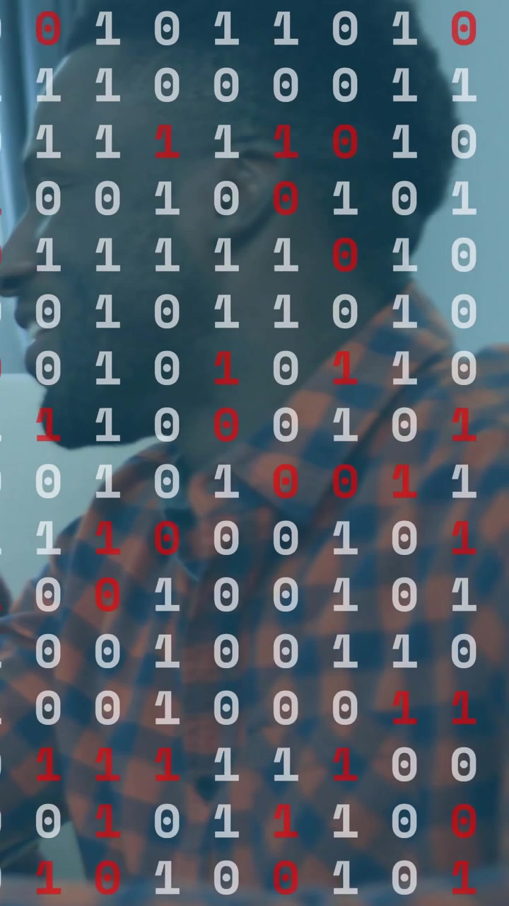 Vertical video: Tech host recording, adjusting mic in room while binary overlay revealing him