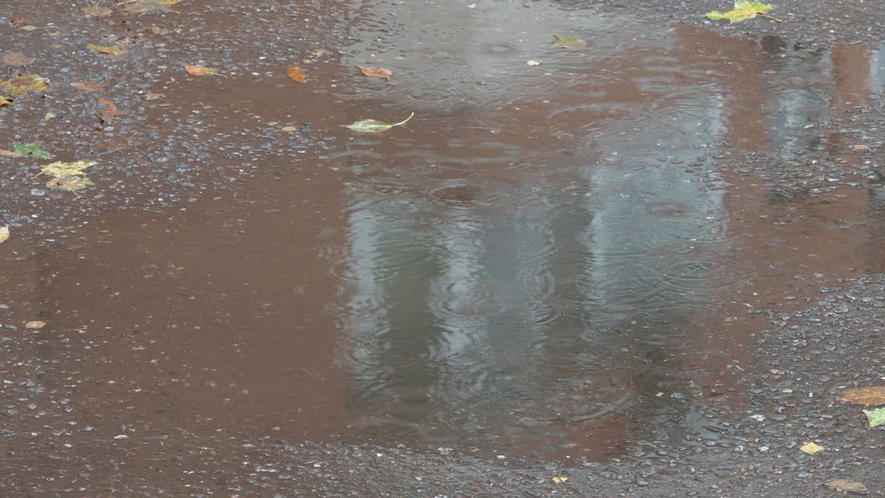 reflection of urban house in puddle on wet road