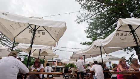 people enjoying food and drinks at outdoor tables