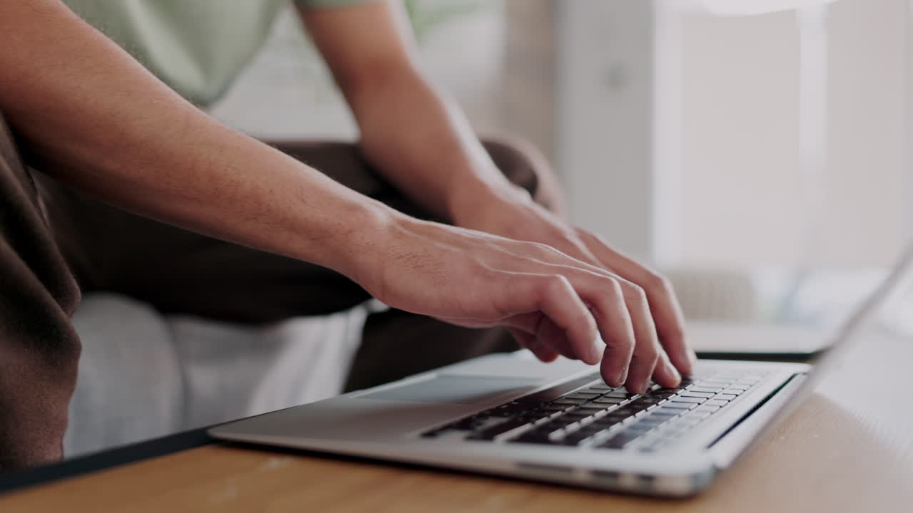 Freelancer hands typing on a laptop with a remote