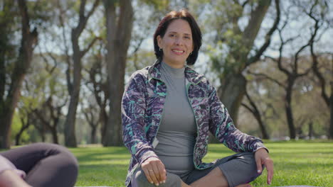 smiling woman meditating in a park