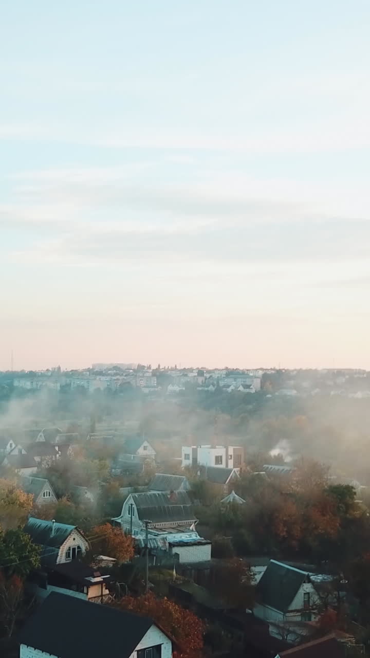 smoke are enveloping the private sector of the city as a result of a fire after a drought. Aerial view Vertical video
