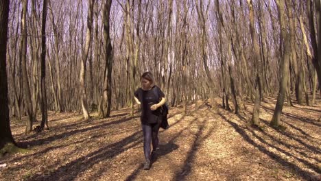 a young blond woman alone in the woods organizes her day pack