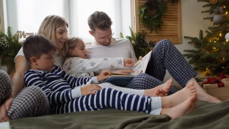 Familia-Leyendo-Libros-En-La-Mañana-De-Navidad