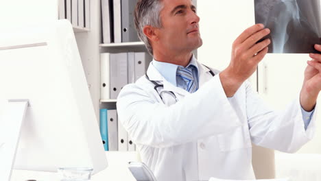 Doctor-examining-an-xray-at-his-desk