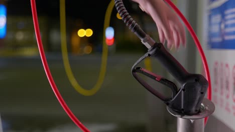 person picks up a car wash sprayer at night