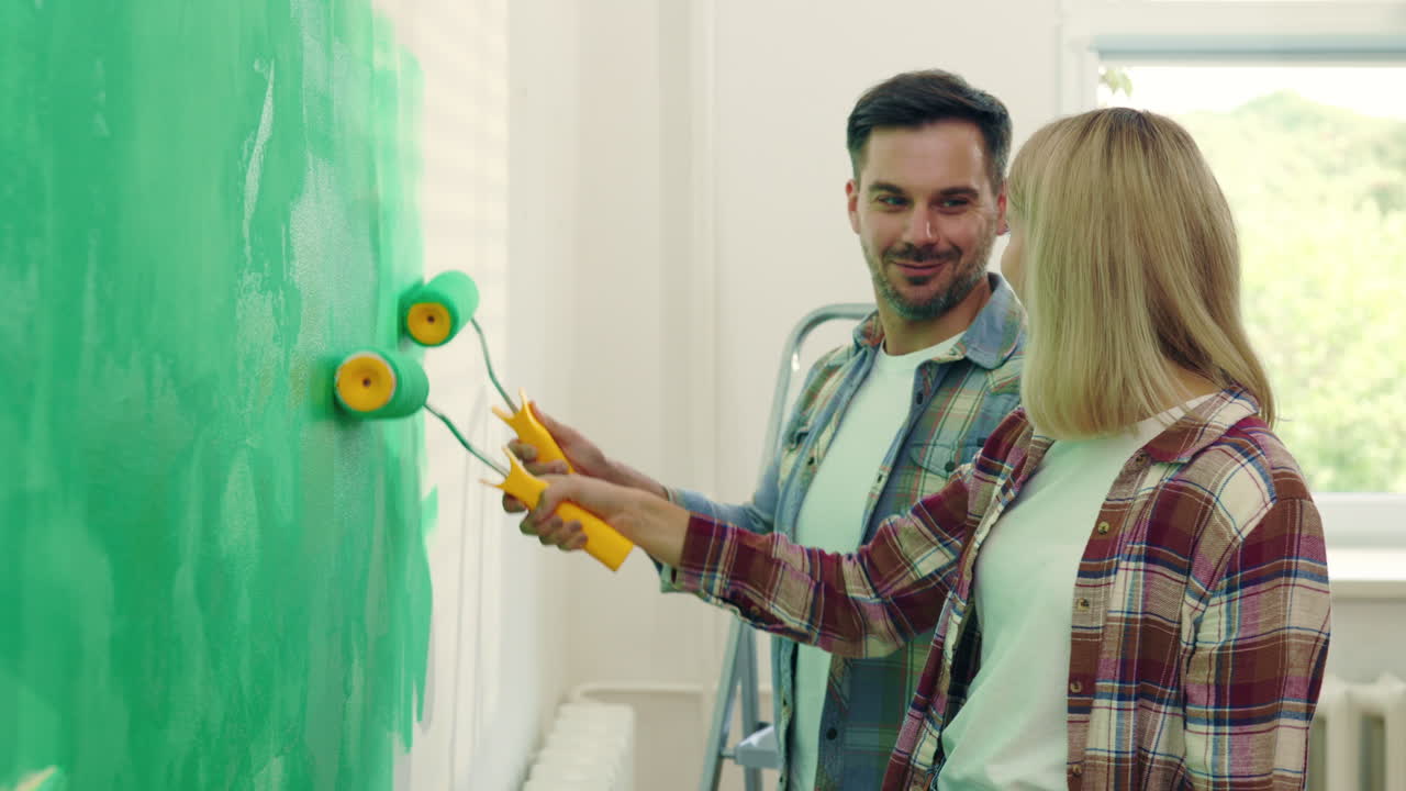 Couple Painting a Wall Green
