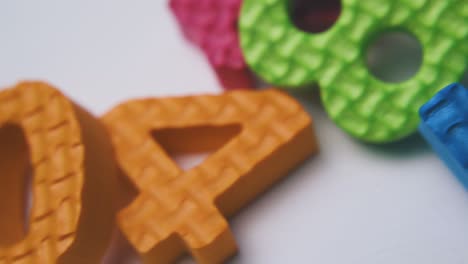 motion past pile of foam rubber numbers on white surface