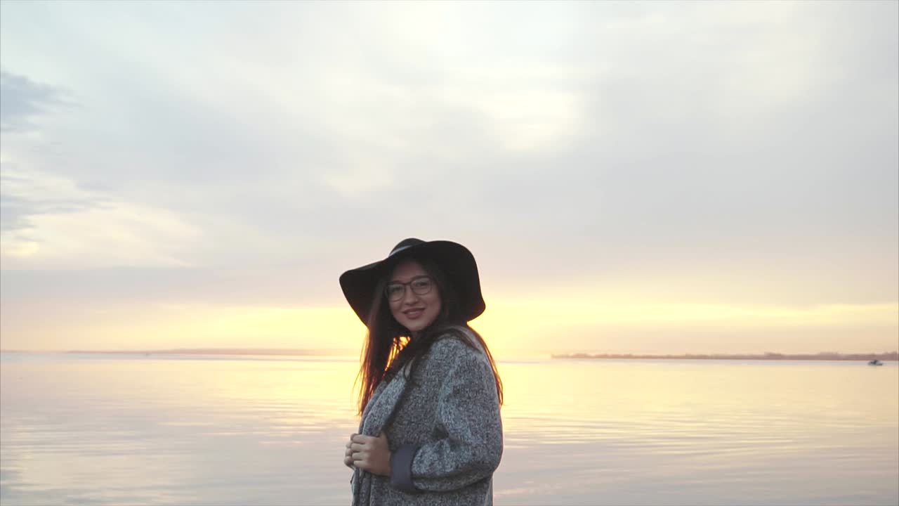Woman enjoying a sunset by the river