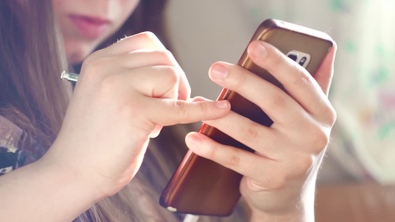 Woman using a smartphone with a stylus