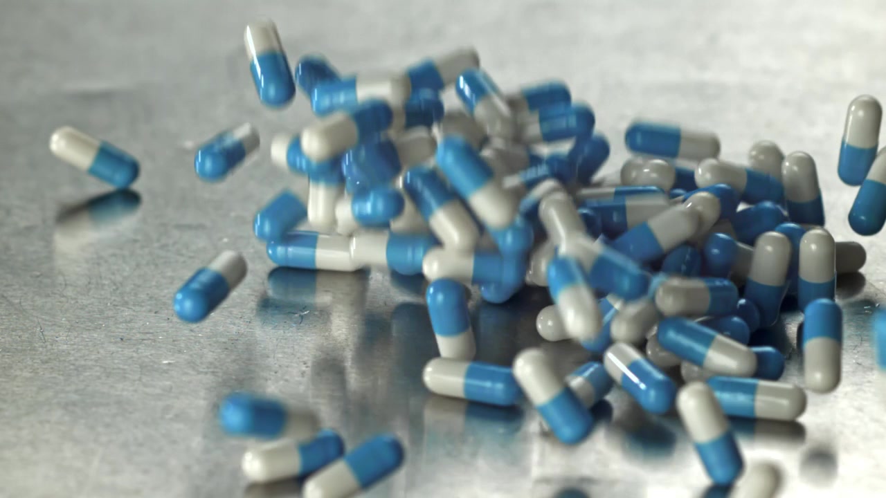 Capsule mediche blu e bianche che cadono al rallentatore