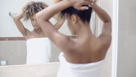 woman arranging her exotic curly hair