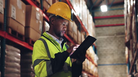 trabajador de almacén que utiliza una tableta para administrar el inventario