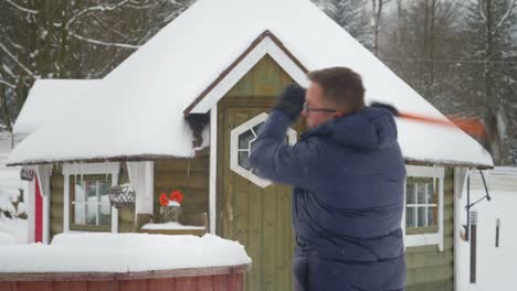 hombre tratando de romper el hielo con un gran martillo en un ambiente frío y nevado