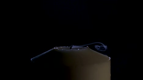 imágenes macro en cámara lenta de una vela blanca sobre un fondo oscuro