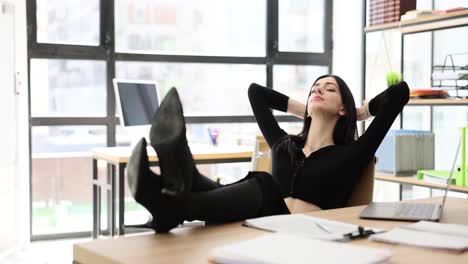 woman relaxing with feet on desk in office