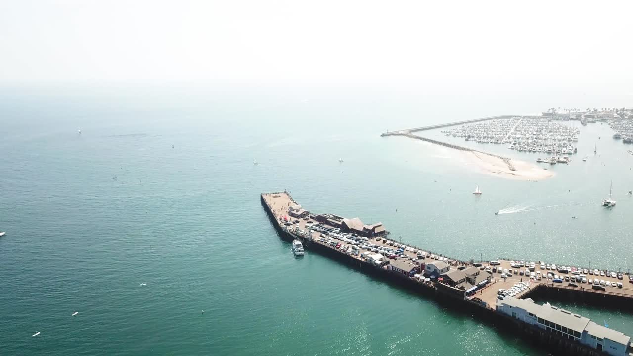 Orbital of Santa Barbara Pier with a jet ski going under pier and boats in the blue ocean