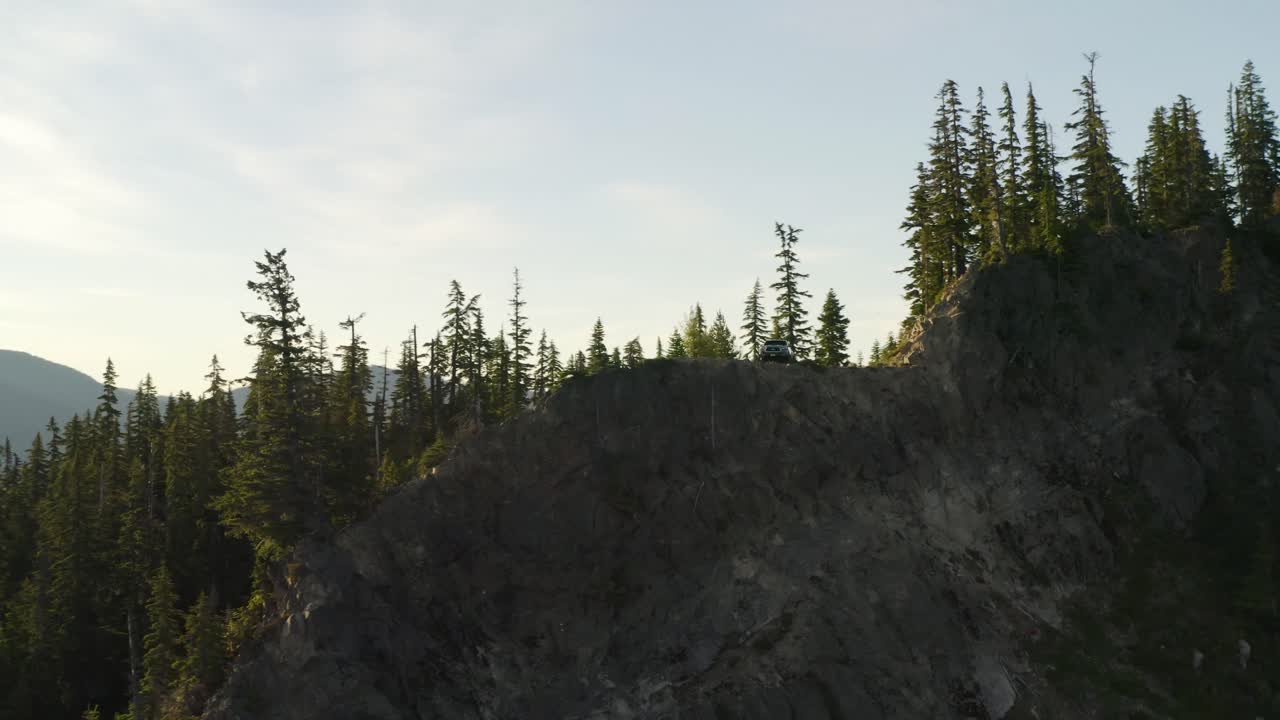 camión se encuentra en el borde de la cumbre durante la hora dorada puesta de sol, antena, círculo pan