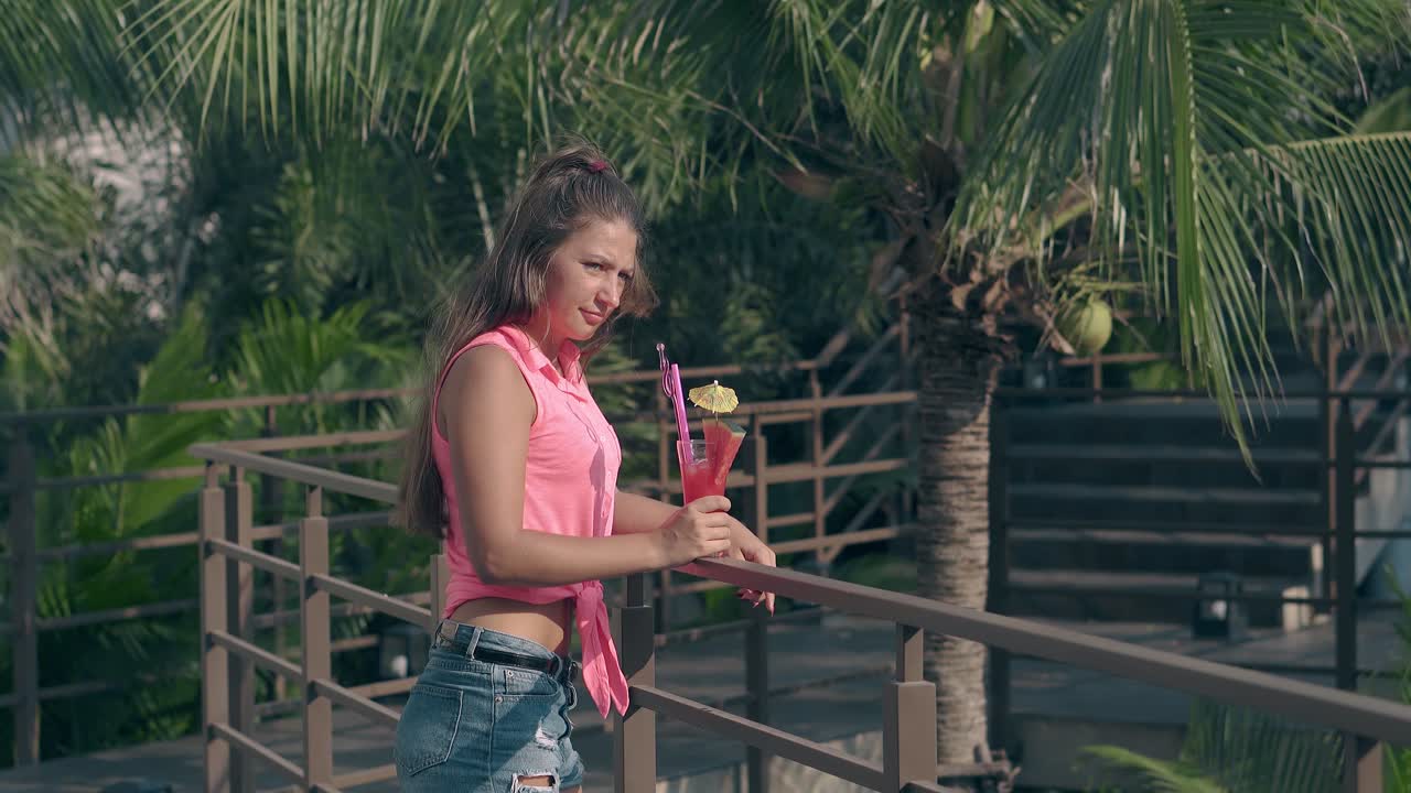 una dama de largo cabello marrón se apoya en las barandillas del puente oscuro