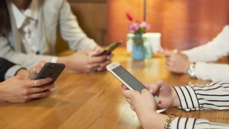 close-up of girls' hands typing messages on smartphones