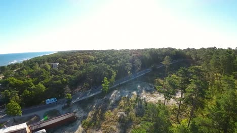 Aerial-FPV-Flying-Towards-Open-Clearing-Beside-Forest-Road-Path