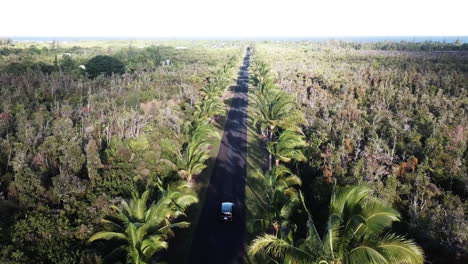 Aerial-view-following-behind-car-driving-through-countryside,-Kauai,-Hawaii