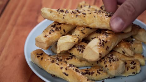 baked dough sticks covered with seeds on the baking sheet