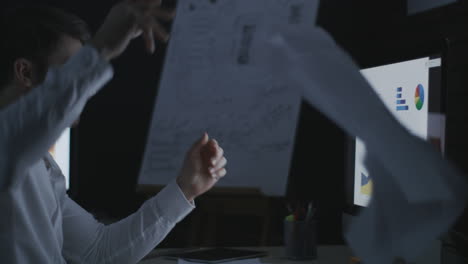 evil business man throwing data document on computer table in dark office