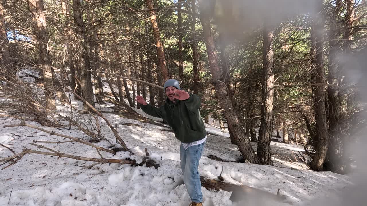 Homem brincando na neve em uma floresta