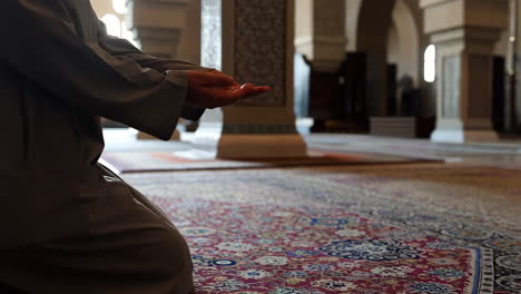 person praying in a mosque on a prayer rug