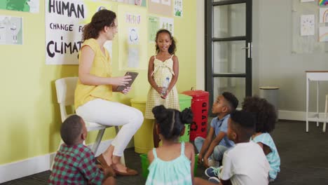 Video-Einer-Glücklichen-Kaukasischen-Lehrerin-Und-Einer-Klasse-Verschiedener-Schüler,-Die-Im-Klassenzimmer-Ökologie-Studieren