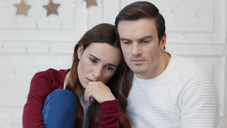 retrato de una pareja pensando sentada en la sala de estar. una mujer triste mintiendo sobre el hombro de un hombre