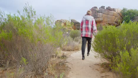 homem a caminhar no caminho para a montanha rochosa 4k