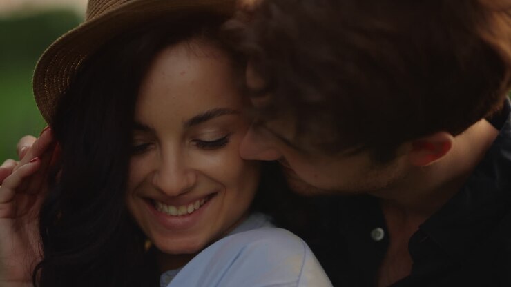 Couple souriant exprimant de la tendresse en extérieur