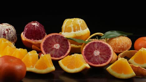 citrus fruits, sliced decoratively, on a black wooden table.