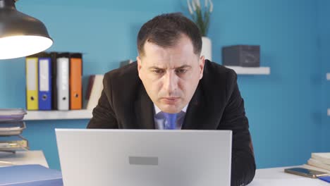 Businessman-looking-at-computer-in-office.