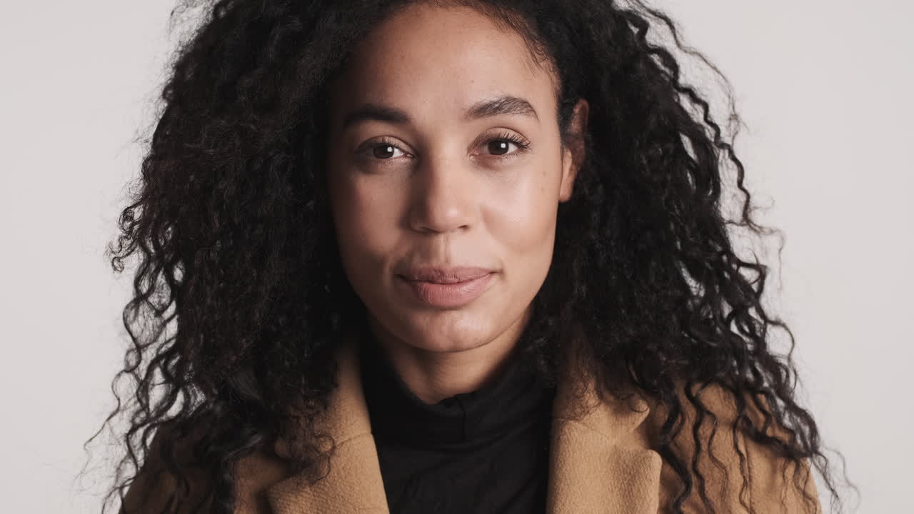 африканско-американская женщина смотрит в камеру.