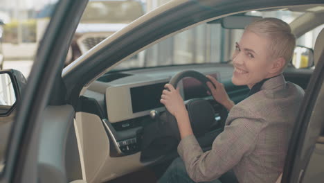 woman test-driving a new electric vehicle at a dealership