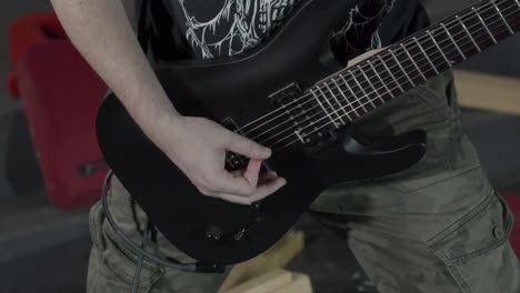 heavy metal guitarist playing on a black seven string guitar