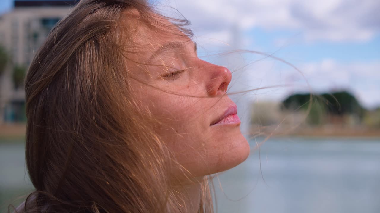 primer plano cardán de la cara de la mujer con los ojos cerrados disfrutando del momento soleado