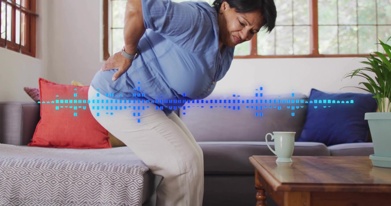 Senior woman pushing from seat holding back rising while steadying as blue health waveform crossing