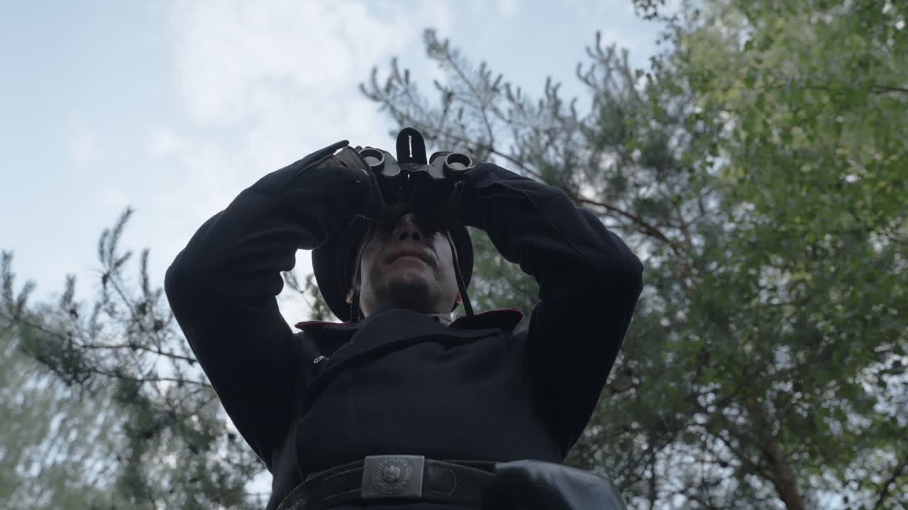 Soldier with binoculars in a forest