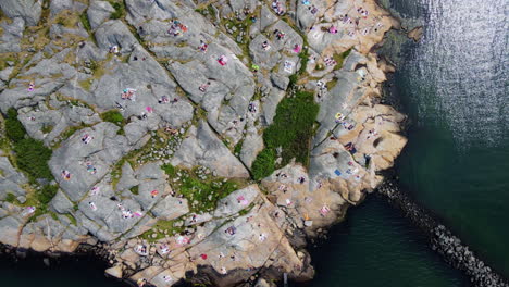 Turistas-Haciendo-Un-Picnic-En-La-Costa-Rocosa-En-La-Península-De-Saltholmen,-Gotemburgo,-Suecia---Drone-Aéreo