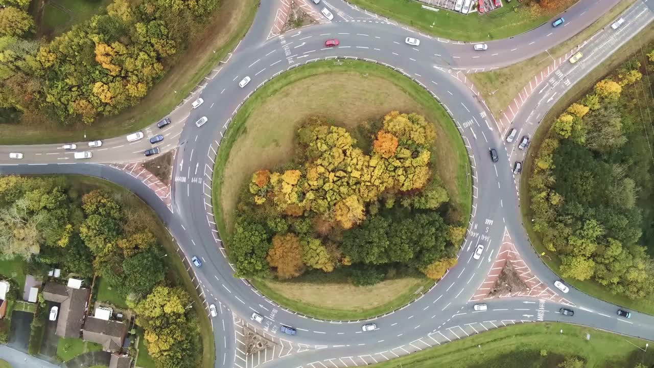 Drone aerial view rotating above roundabout traffic intersection