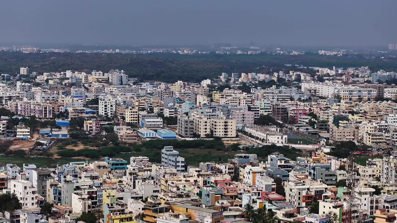 Edifici residenziali con appartamenti, sentiero del lago asciutto, foresta urbana e la Iris Florets World School a Suraram, Hyderabad, Telangana, India. Di giorno, carrellata, ripresa con drone, 4K