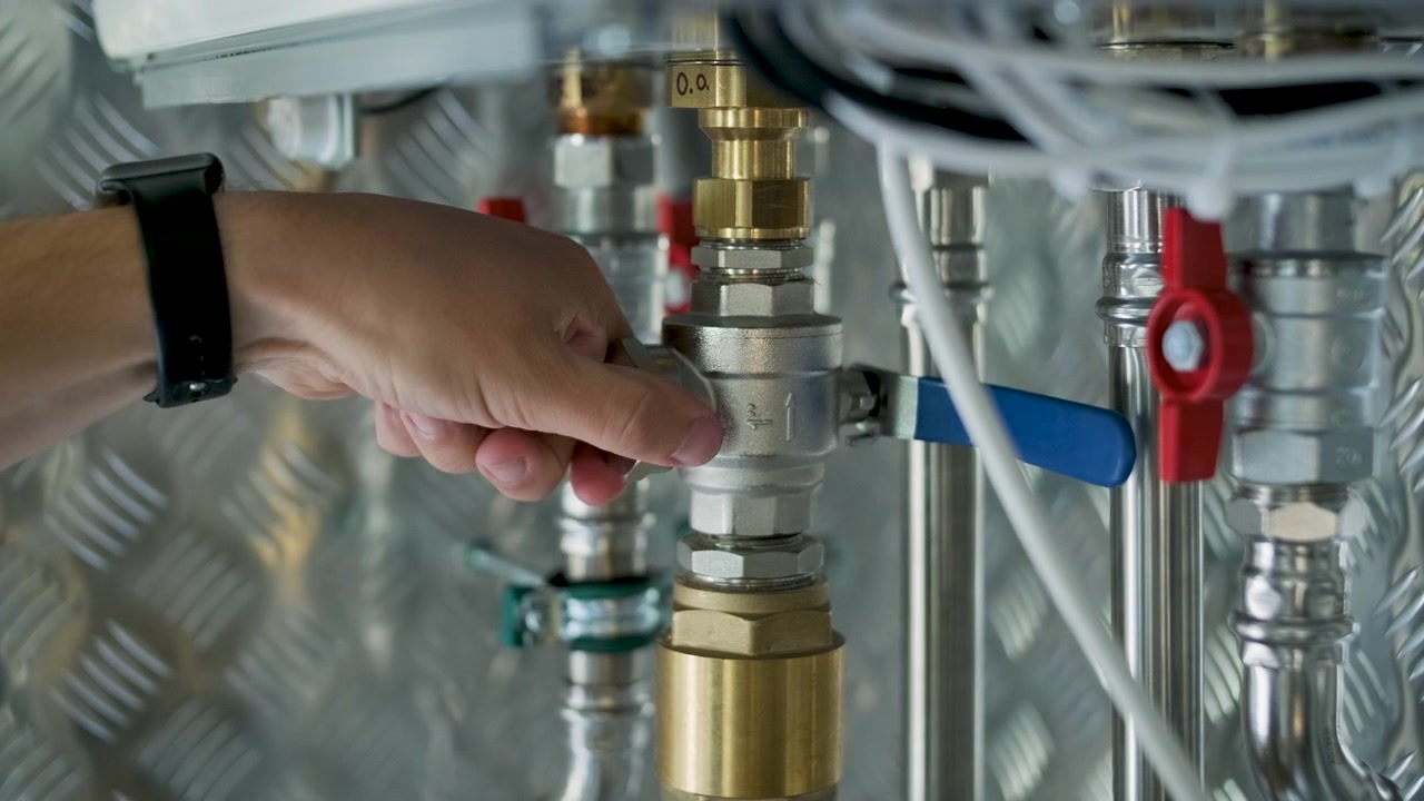 Technician Adjusting Valve on Industrial Heating System