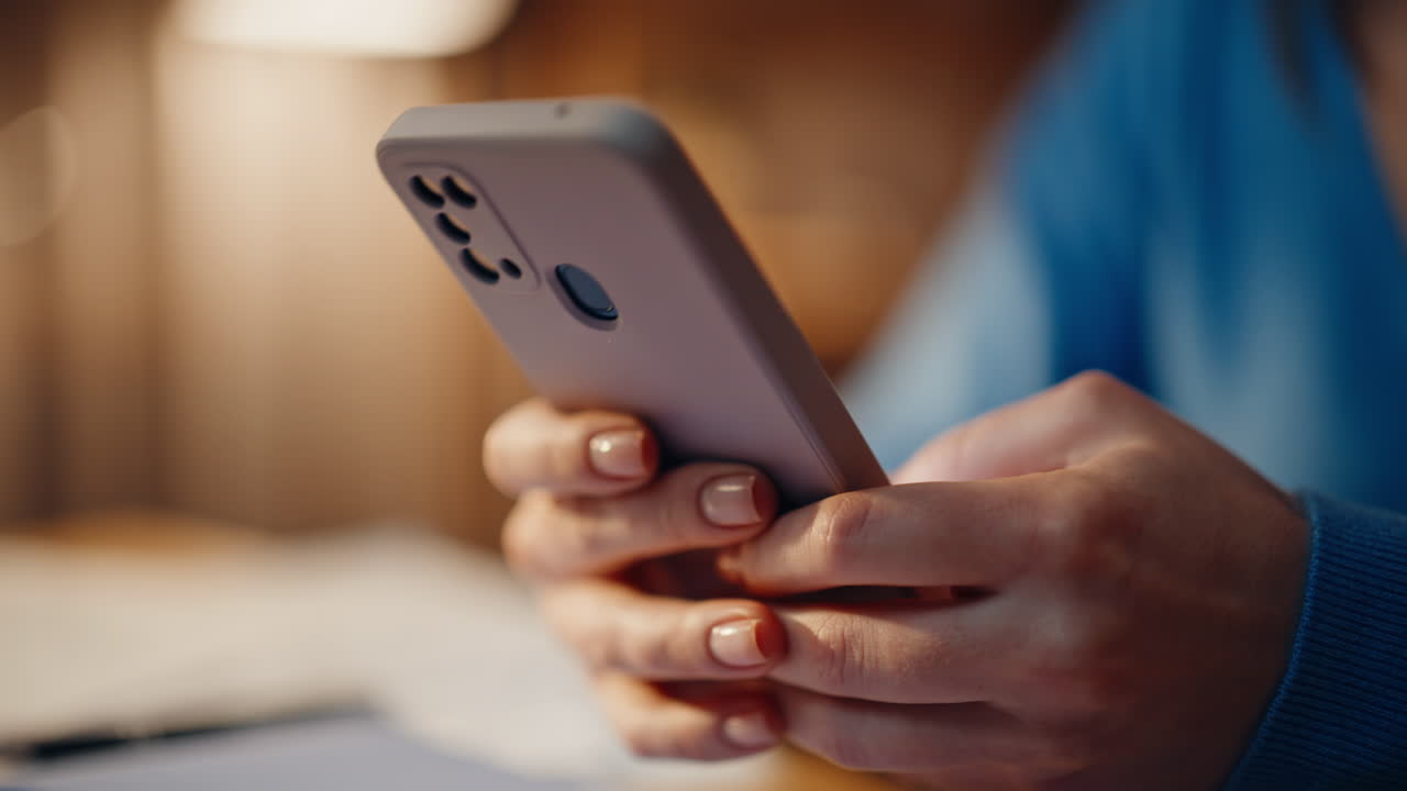 Lady hands typing cellphone in evening home closeup. Unrecognizable woman