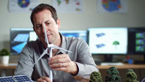expert examining wind turbine model for sustainable energy solutions