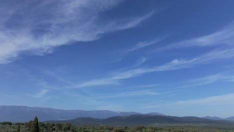 Flug-In-Einer-Wunderschönen-Landschaft-In-Einem-Tal-Mit-Seinen-Bergen,-Die-Mit-Einer-Drehung-Der-Kamera-Den-Beeindruckenden-Blauen-Himmel-Mit-Weichen,-Geriebenen-Wolken,-Sogenannten-Cirruswolken,-An-Einem-Frühlingsnachmittag-Visualisieren